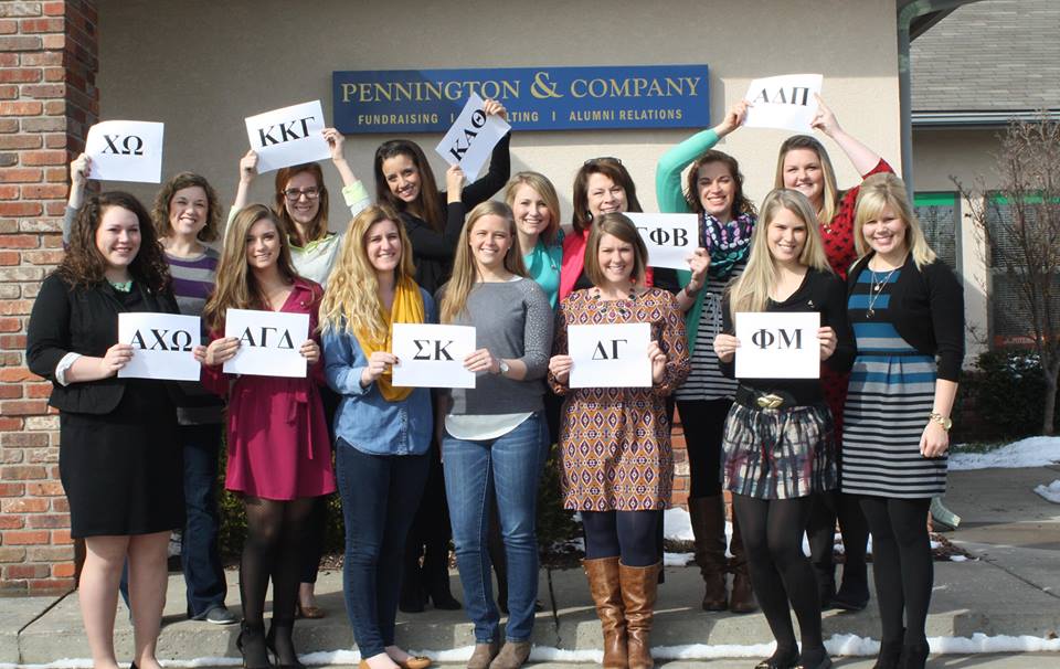 Pennington & Company team members holding the letters of their own sororities outside the company office